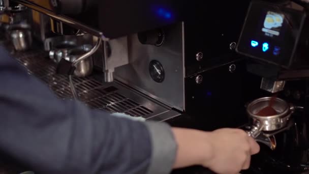 Guy barista poner café en el cuerno de la máquina de café antes de preparar café con leche — Vídeo de stock
