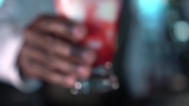 Barmen tezgahta bir bardak lav akışı kokteyli sunar.