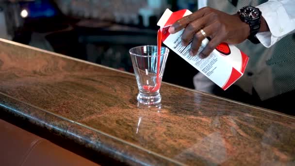 Barman giet aardbeiensiroop in een glas op de toonbank, lava flow cocktail — Stockvideo