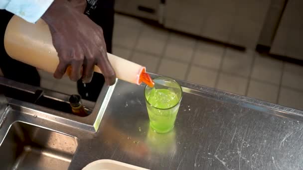 Bartendern häller gul vätska i ett glas is, Sex in the Ocean cocktail — Stockvideo