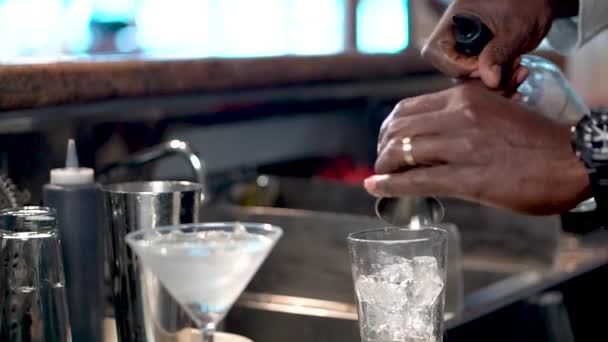 Il barman versa l'alcool in un bicchiere con ghiaccio, primo piano di cocktail Cosmopolitan — Video Stock