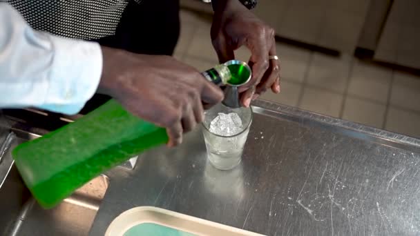 Barkeeper gießt grüne Flüssigkeit in ein Glas Eis, Sex im Ozean-Cocktail — Stockvideo