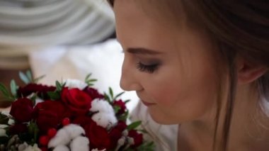 Genç gelin kokusu çiçekler ve daha sonra kameraya bakarak