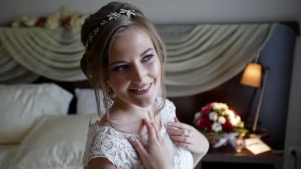 Молодая невеста улыбается и смотрит в окно — стоковое видео