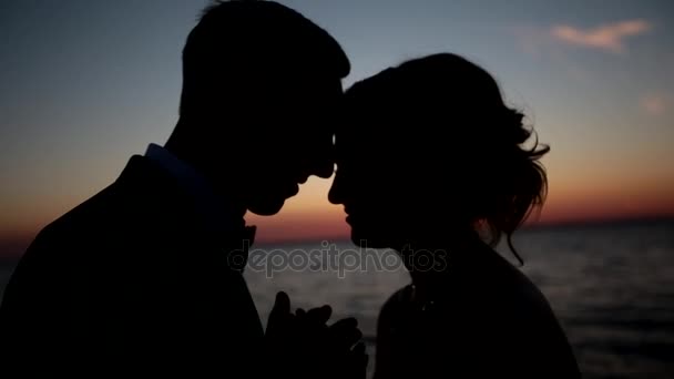 Pareja parada en la playa al atardecer. Primer plano — Vídeos de Stock