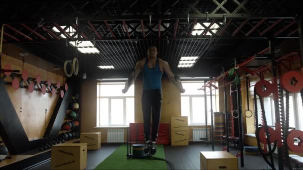 Um atleta fazendo exercícios sobre os anéis no salão de crossfit — Vídeo de Stock