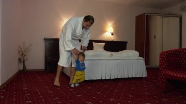 Bir otel odasında yürümek için bir çocuk baba öğretir