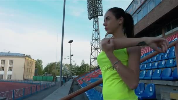 Het meisje aan het warmrijden in het stadion — Stockvideo
