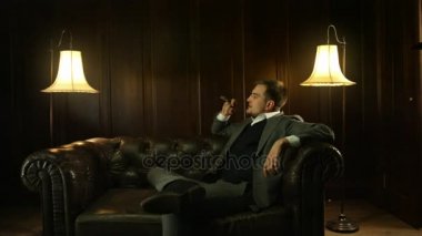 Yakışıklı genç bir puro barda sigara pahalı bir takım elbise