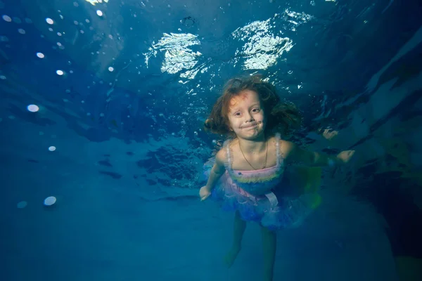美丽的小女孩在水池里游泳 穿着漂亮的衣服向着阳光和微笑 在水面下射击 景观视图 — 图库照片