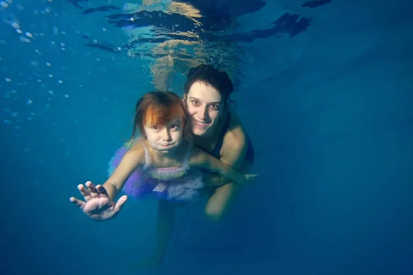 Küçük Kız Eğitmen Yüzmek Sualtı Gülümseyerek Mavi Bir Arka Plan — Stok fotoğraf