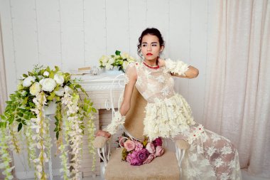 Genç Asyalı kız modeli stüdyoda vintage sandalye üzerinde oturan ve yan arıyorum güzel iç çamaşırı
