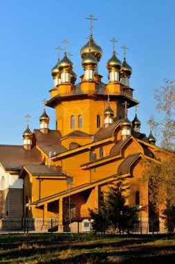 Gün batımında mavi gökyüzü arka plan üzerinde altın kubbe ile eski ahşap kilise. Rusya, Belgorod