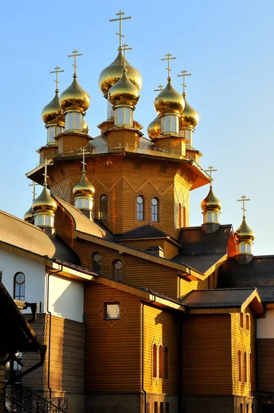 Église en bois avec dômes d'or a été consacrée par le soleil sur un fond bleu ciel. Russie, Belgorod — Photo