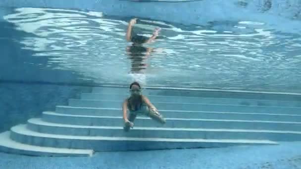 Adolescente nada debaixo d 'água na piscina com óculos para nadar na câmera . — Vídeo de Stock