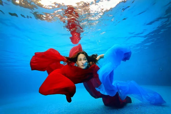 Chica Bajo Agua Enredada Las Telas Rojas Azules Mirando Cámara —  Fotos de Stock