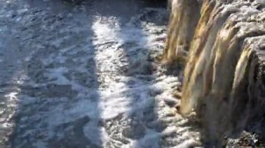 Kirli su hızlı bir şekilde çöp ile nehre akıyor. Yakın çekim. Panorama sağdan sola. 4k, 25 fps
