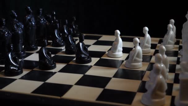 Pièces d'échecs slaves noir et blanc debout sur un échiquier sur un fond sombre. Gros plan, détail. Rotation. 4K, 25 ips 