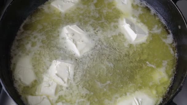 Gelbe Butter wird in einer Pfanne geschmolzen. das heiße Öl kocht und blubbert. — Stockvideo