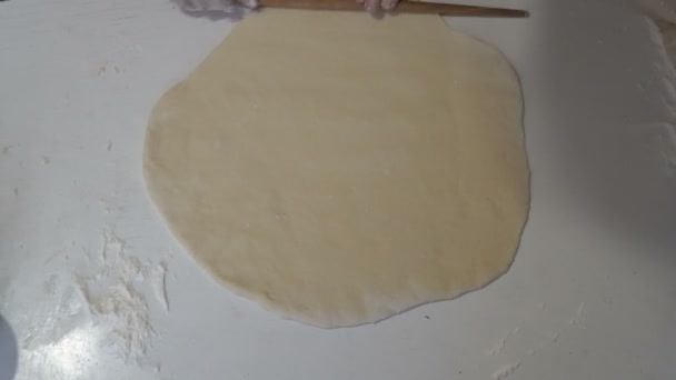 Женщина дома деревянная скалка скатывает тесто в круглую форму на белом столе . — стоковое видео