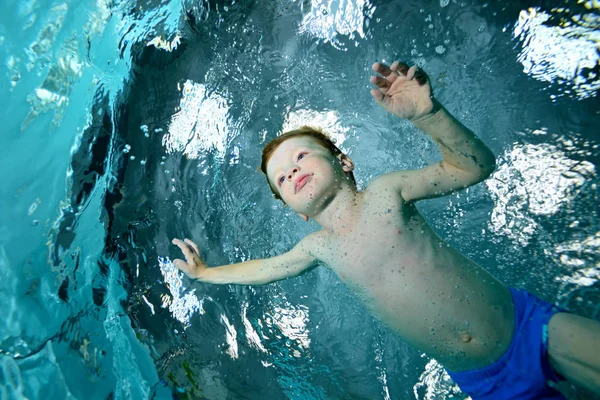 少年スポーツのプールに泳ぎに行っています 青色の背景に水の下で泳ぐ 楽しみに 肖像画 浅薄の背景に水の下で撮影 水平方向の表示 — ストック写真