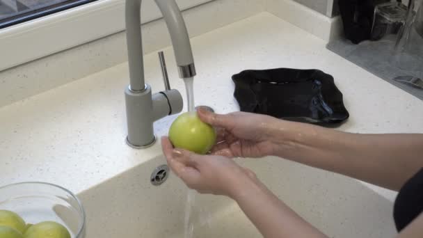 Μια γυναίκα πλένει πράσινα μήλα στο νεροχύτη της κουζίνας. Εργασία. Υγιεινή διατροφή. Κοντινό πλάνο. 4ια. — Αρχείο Βίντεο