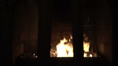 Cam kapıların arkasındaki şöminenin içindeki güzel ateşe bir bak. Şömine kapıları insan müdahalesi olmadan açılıp kapanıyor. Ateş cama yansıyor. Kavramsallık. - Yakın çekim. 4k.