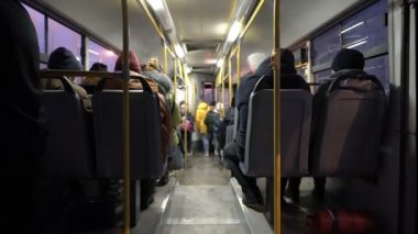 View inside the passenger compartment of the bus. The bus with people goes through the night city. Lights flash past the Windows. View from the back of the bus. Blurred background. 4K.