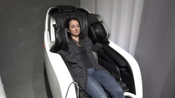 Une adulte fatiguée reçoit un massage assis à la maison dans une chaise de massage. Concept. 4K . — Video