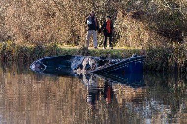 Seyirciler ile yangından sonra kısmen batık kanal tekne