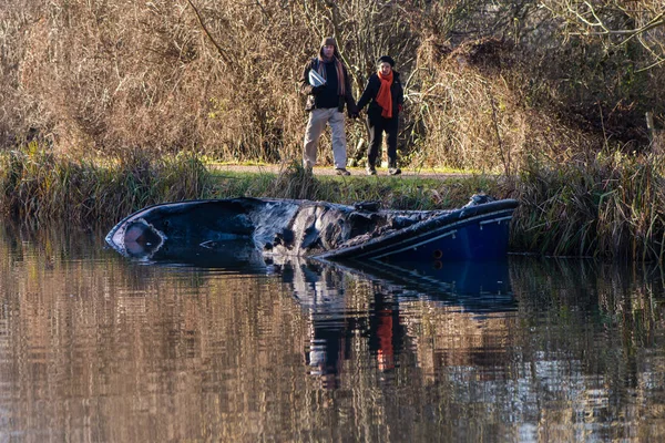 Seyirciler ile yangından sonra kısmen batık kanal tekne