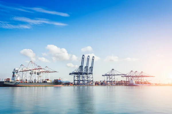 Contenedor Buque de carga de carga con puente de grúa de trabajo en el astillero al atardecer para importación logística Trasfondo de exportación — Foto de Stock