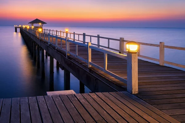 Wood bridge to the sea at sunset. Stock Image