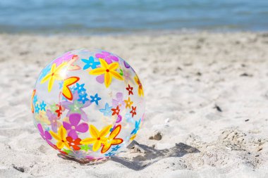  Çok renkli bir şişme top kum plaj üzerinde yer almaktadır. Yaz eğlence kavramı. Boşaltmak