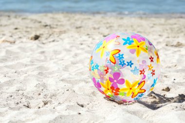  Çok renkli bir şişme top kum plaj üzerinde yer almaktadır. Yaz eğlence kavramı. Boşaltmak