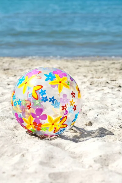  Çok renkli bir şişme top kum plaj üzerinde yer almaktadır. Yaz eğlence kavramı. Boşaltmak