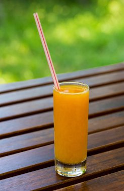 Ahşap masa arka plan üzerine portakal suyu. Yeşil bir arka plan üzerine suyu