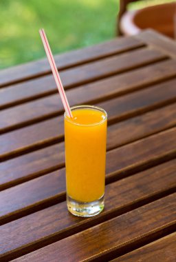 Ahşap masa arka plan üzerine portakal suyu. Yeşil bir arka plan açık havada suyu