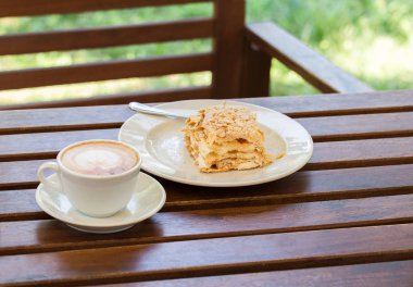 Napolyon kek, cappuccino kahve kafe, Bahçe veranda ahşap bir masa üzerinde