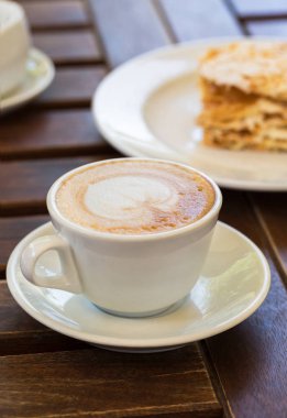 Napolyon kek, cappuccino kahve kafe, Bahçe veranda ahşap bir masa üzerinde