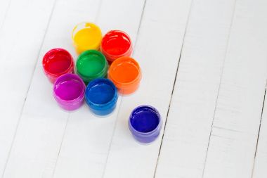 Beyaz ahşap arka plan üzerinde renkli boya ile açık kavanoz. Okul