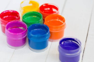 Beyaz ahşap arka plan üzerinde renkli boya ile açık kavanoz. Okul