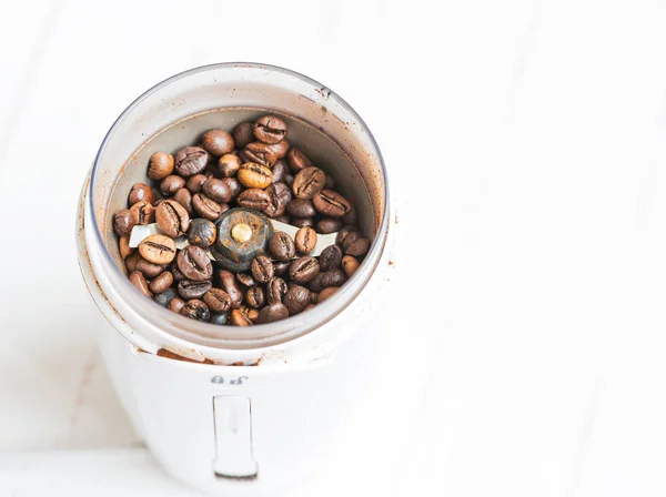 Macro. Freshly ground coffee in electric coffee grinder.