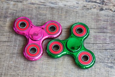 İki yeşil ve koyu kırmızı topluca spinners kahverengi ahşap backgrou üzerinde