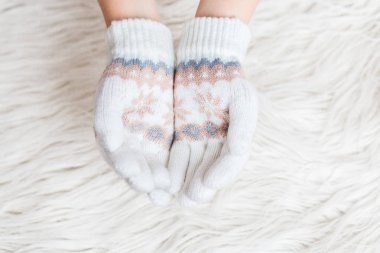 Kış çocuk el mittens beyaz kürk arka plan üzerinde beyaz. Hygge. El ele tutuşarak