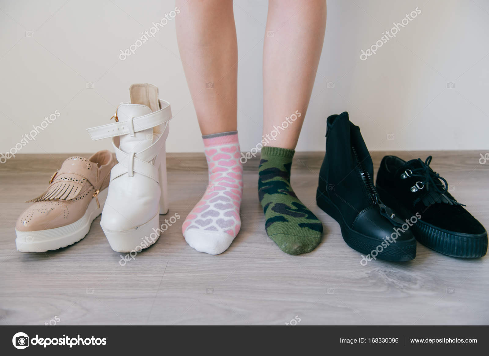 Female naked legs standing on floor. Women`s feet in missmatched cotton