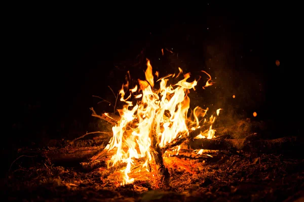 Feuerfunken und Flammen in Bewegung auf schwarzem Hintergrund. Textur und Eruption — Stockfoto