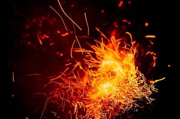 Ogień iskrzy i płomienie w ruchu na czarnym tle. Tekstura i erupcja — Zdjęcie stockowe