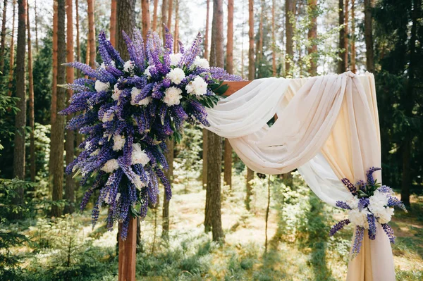 Ahşap arch çiçekler ile evlilik töreni için düğün, perde ve diğer dekorasyon öğeleri Instalar ormanda yer. Çam ağaçları içinde güneşli yaz günü. Kutlama ruh. Cam, tüyler mumlar