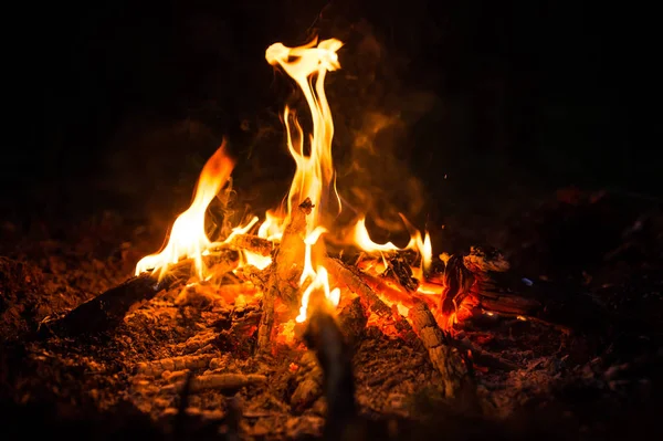 Feuerfunken und Flammen in Bewegung auf schwarzem Hintergrund. Textur und Eruption — Stockfoto